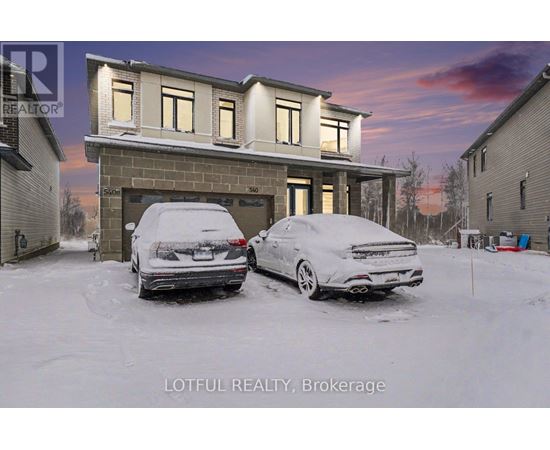 Two cars are parked in front of a house in the snow.