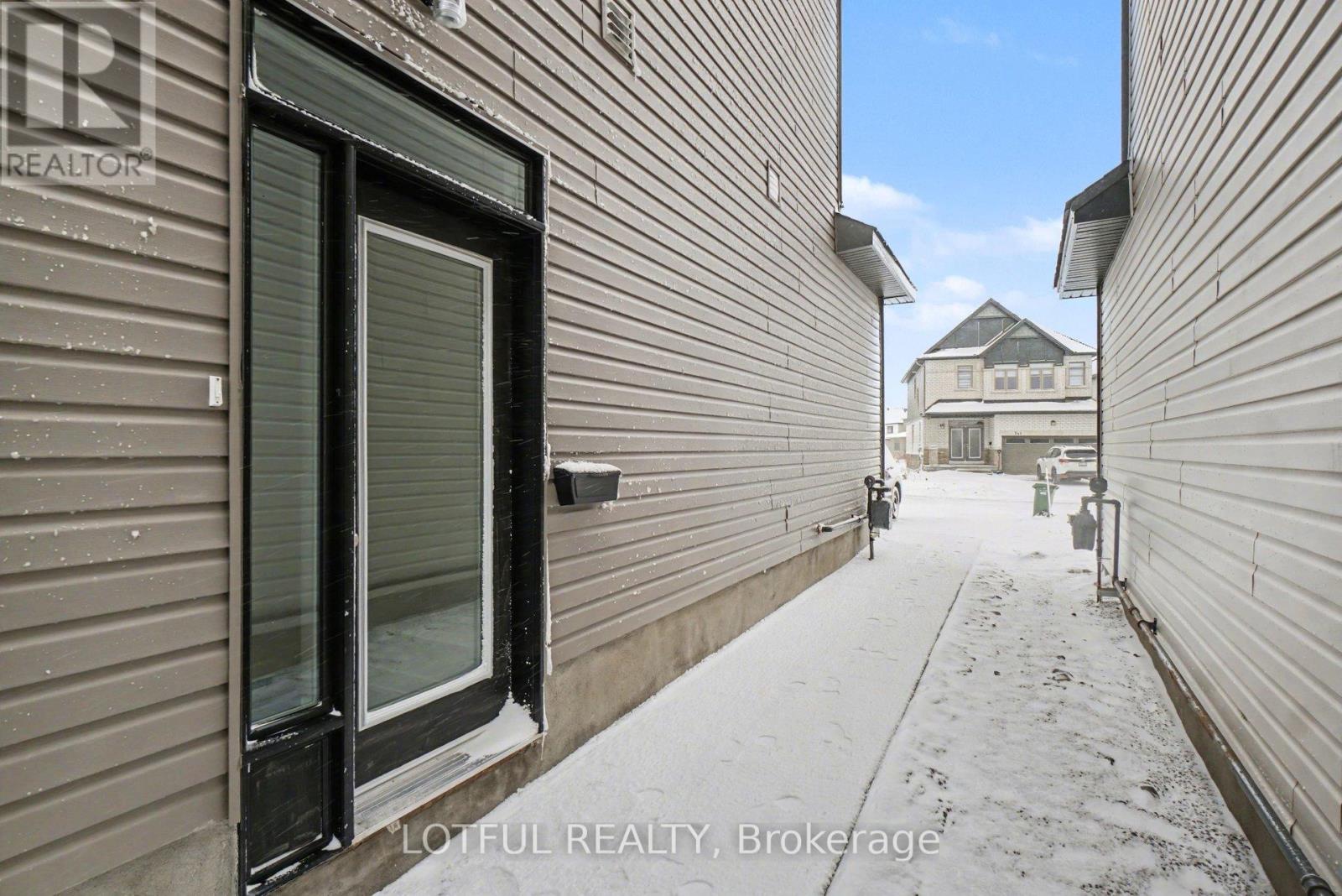A snowy alleyway with buildings on either side and a house in the distance.