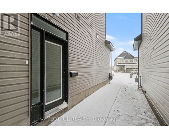 A snowy alleyway with buildings on either side and a house in the distance.