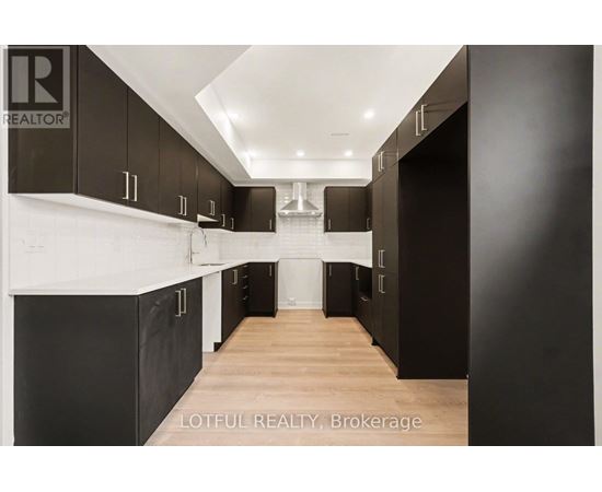 A modern kitchen with black cabinets and a white countertop.
