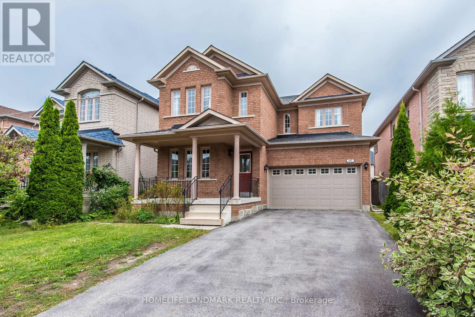 A large, well-maintained house with a driveway in front.