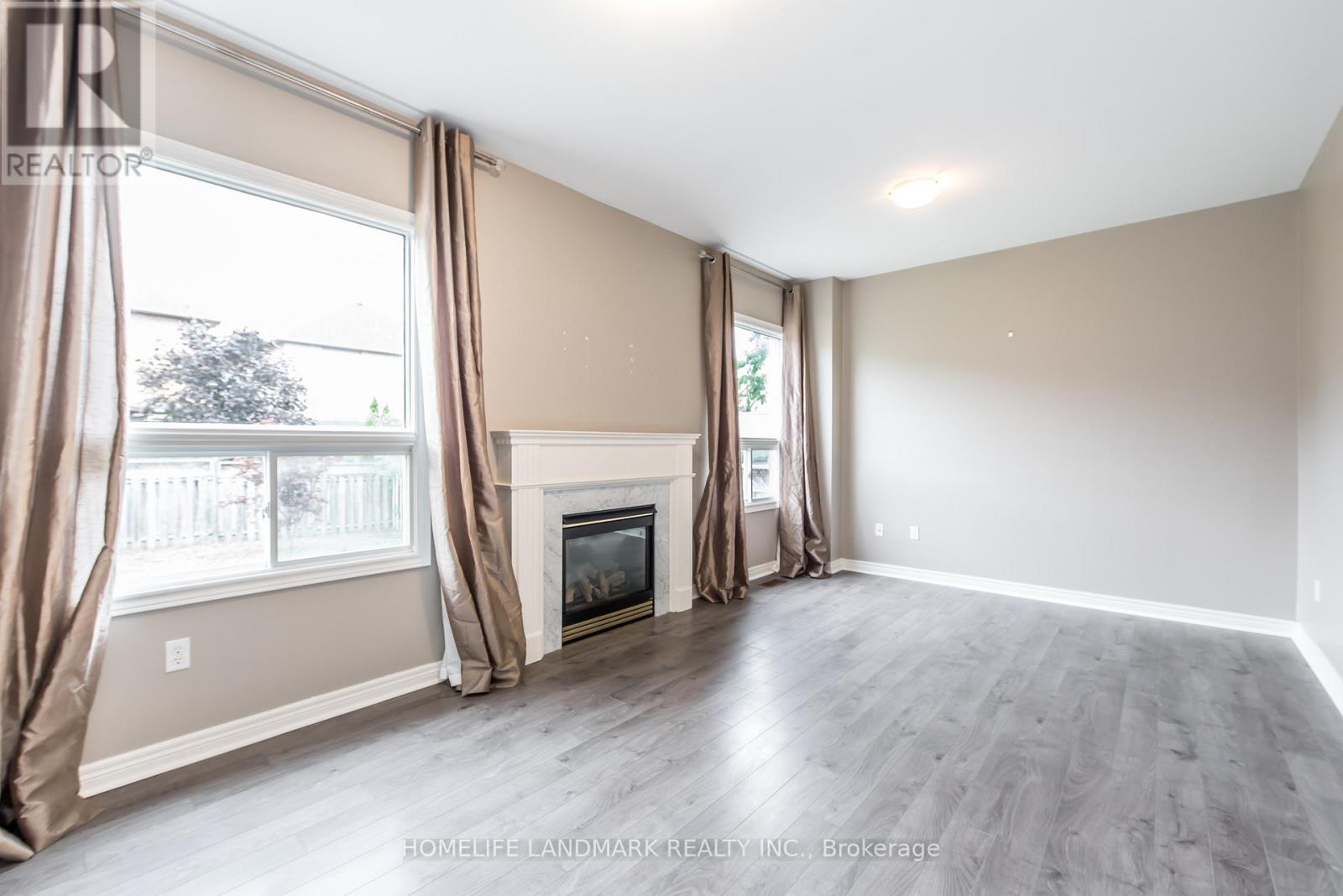A spacious living room with a fireplace and large windows.