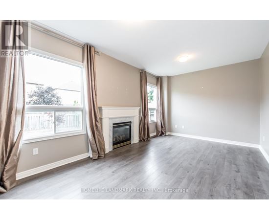 A spacious living room with a fireplace and large windows.