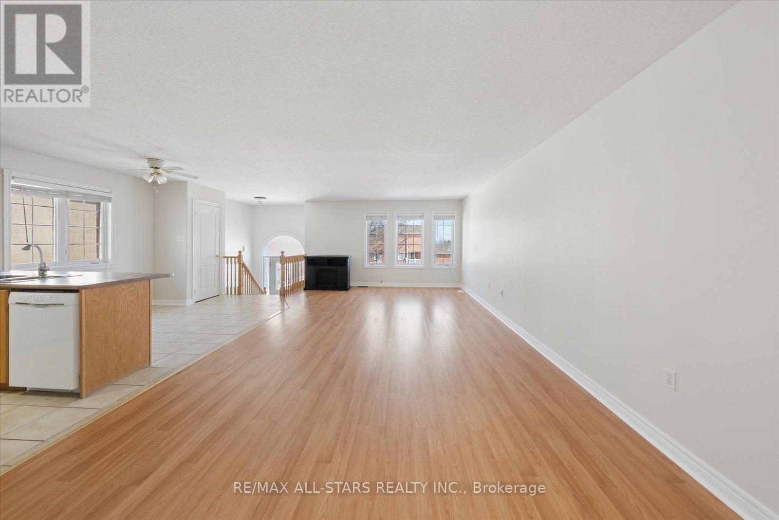 A spacious room with wooden floors and white walls.