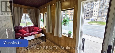 A living room with a red couch and a window overlooking a street.