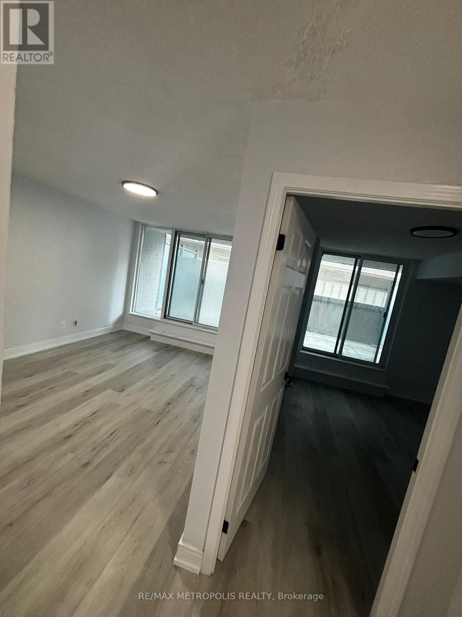 A room with wooden floors and a large window.