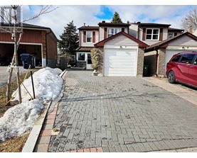 A red car is parked in front of a house with a driveway.