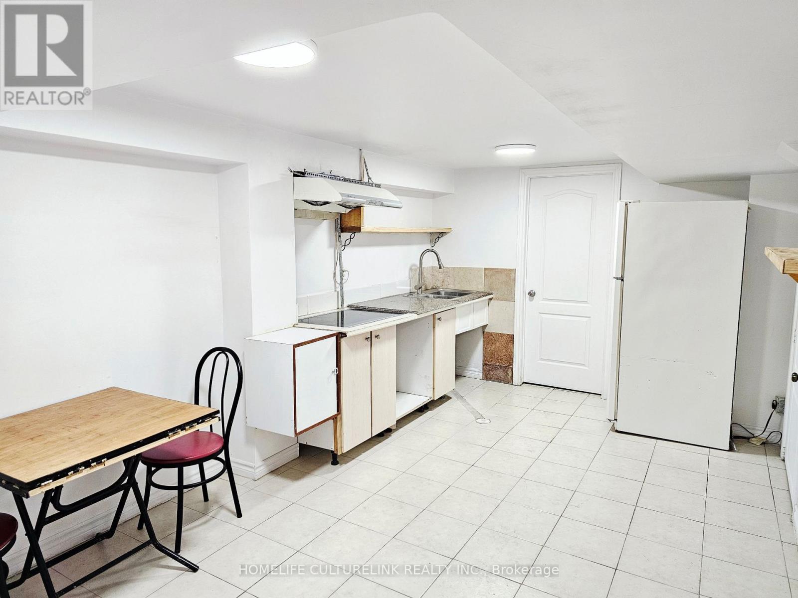 A kitchen area with a table and chairs.