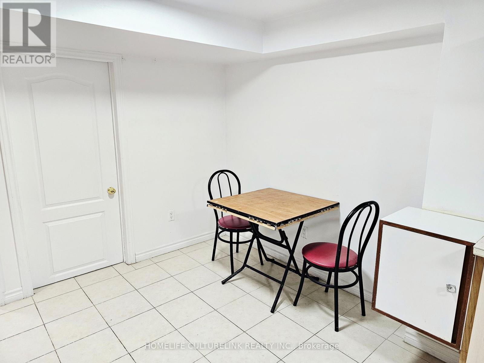 A small dining room with a table and chairs.