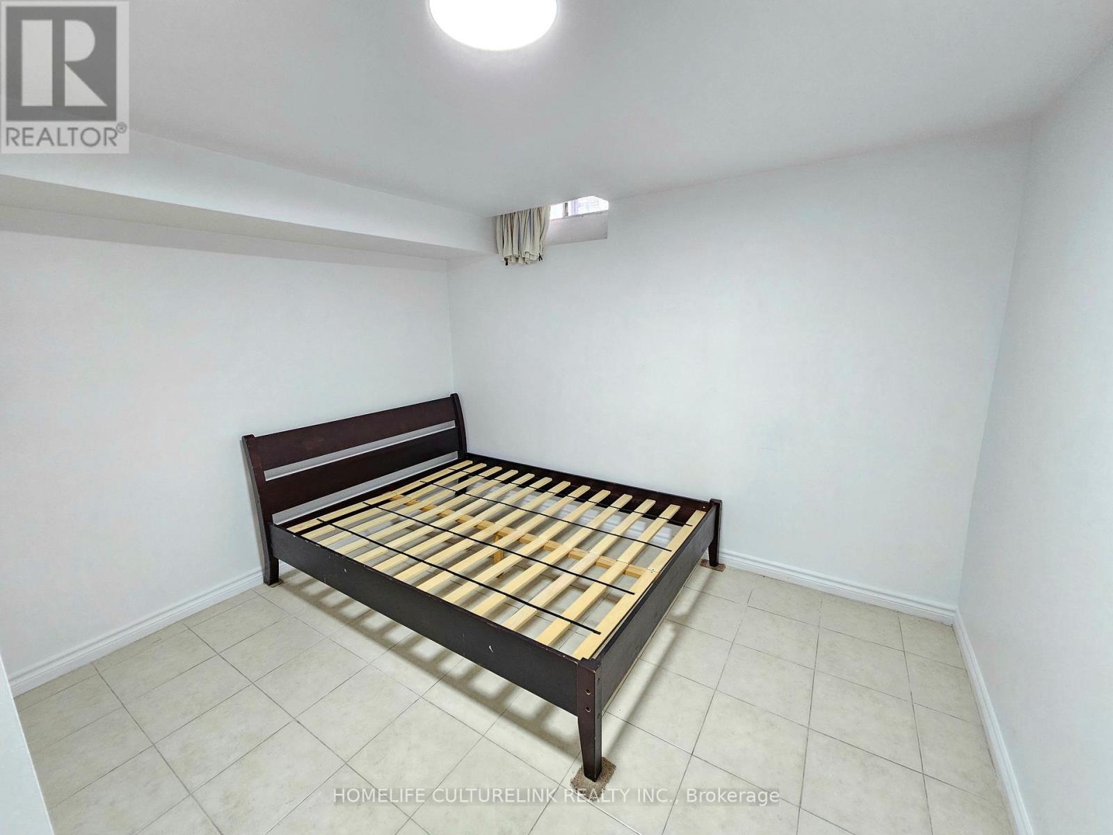 A bedroom with a bed and a ceiling light.