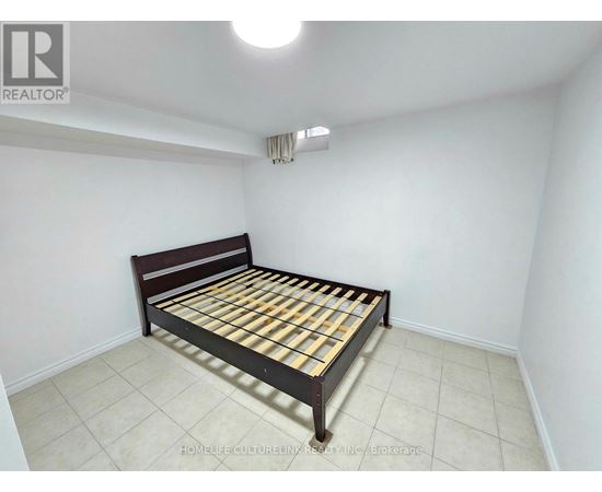 A bedroom with a bed and a ceiling light.
