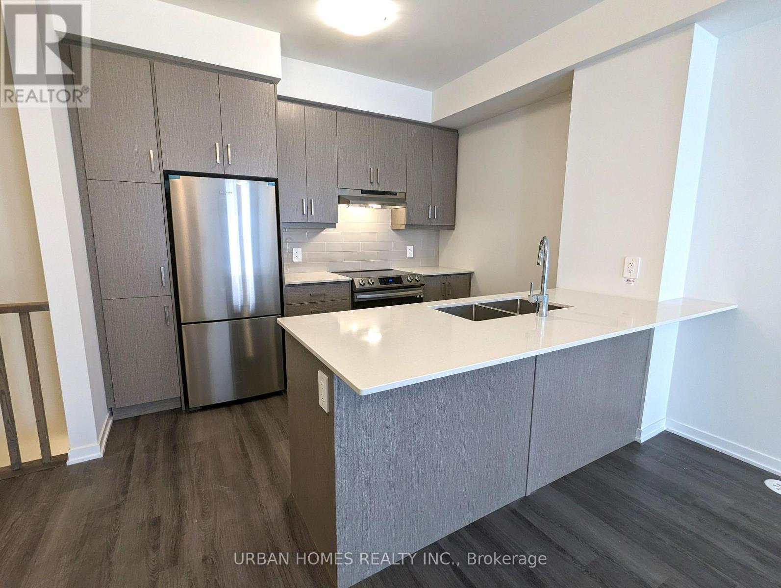 A kitchen with a refrigerator, stove, and sink.