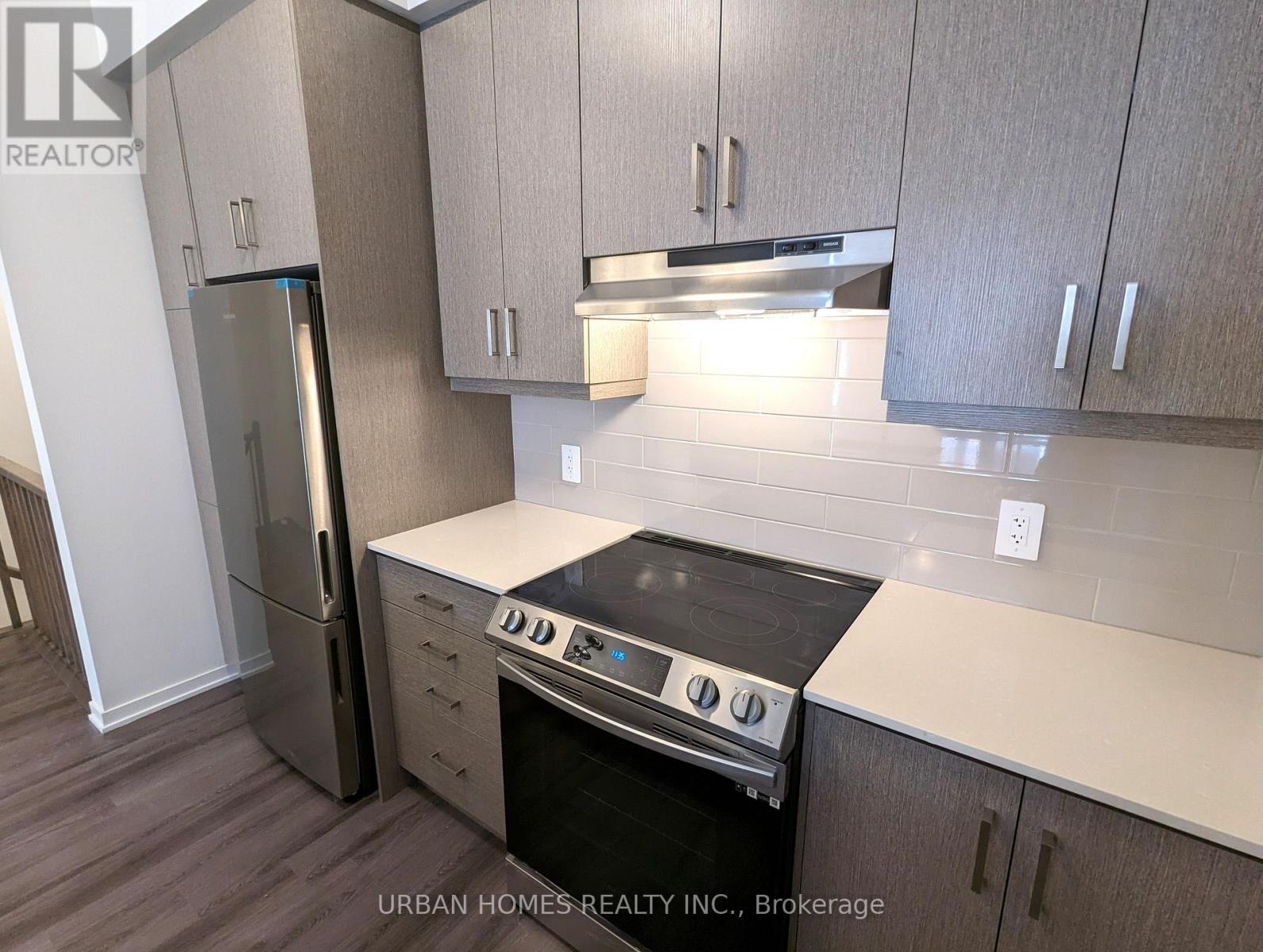 A kitchen with a stove top oven and a refrigerator.