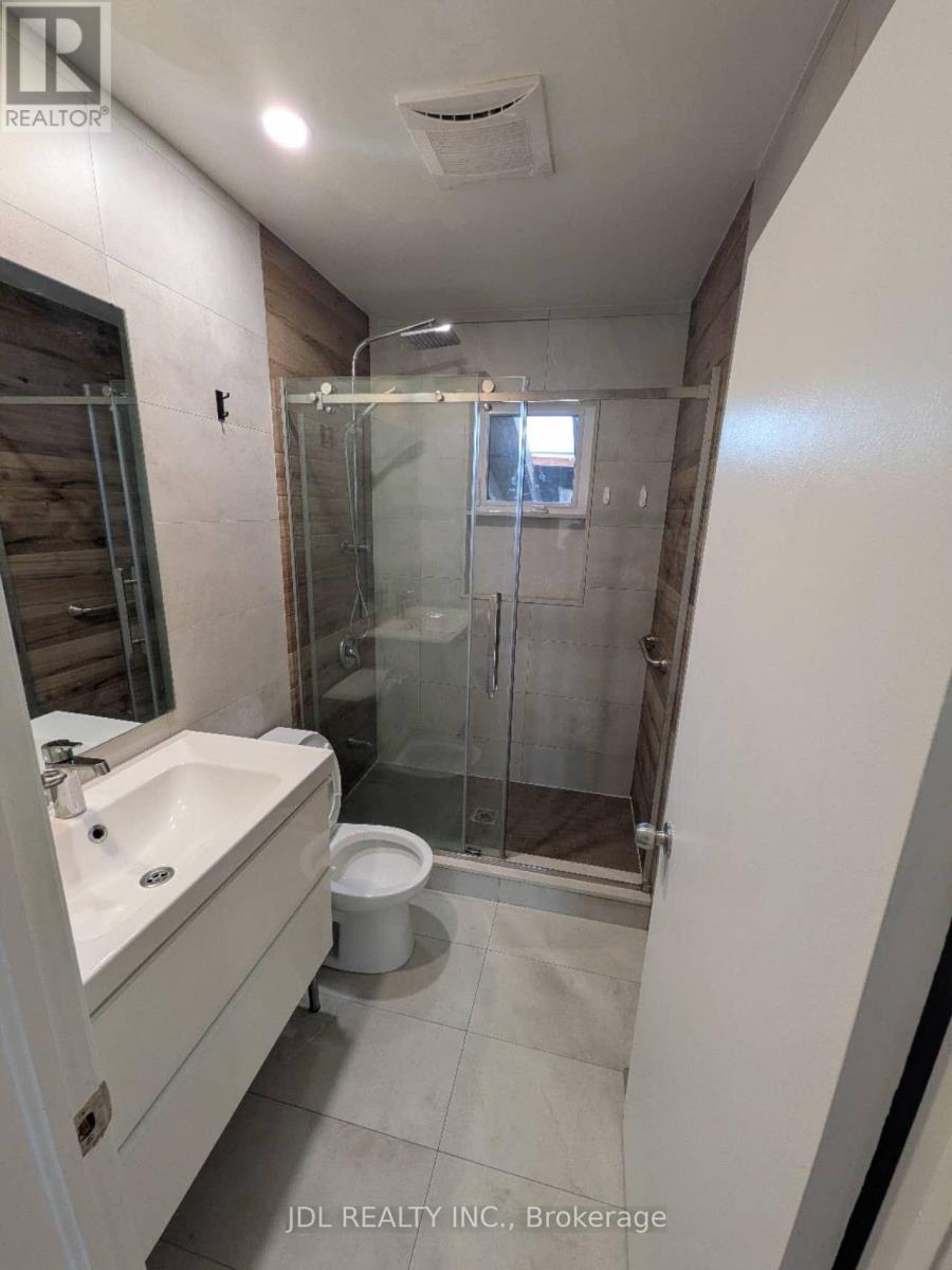 A bathroom with a sink, toilet, and shower.