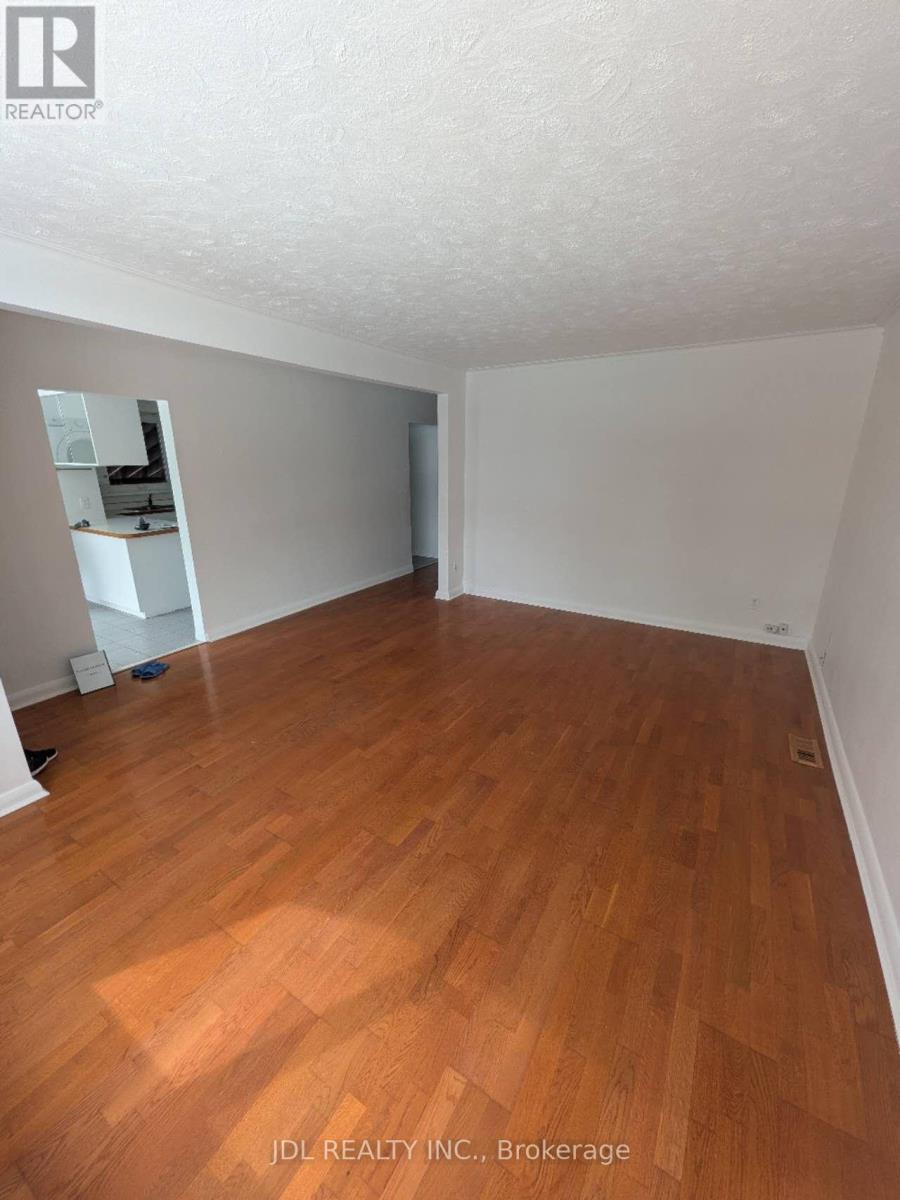 A room with wooden flooring and white walls.