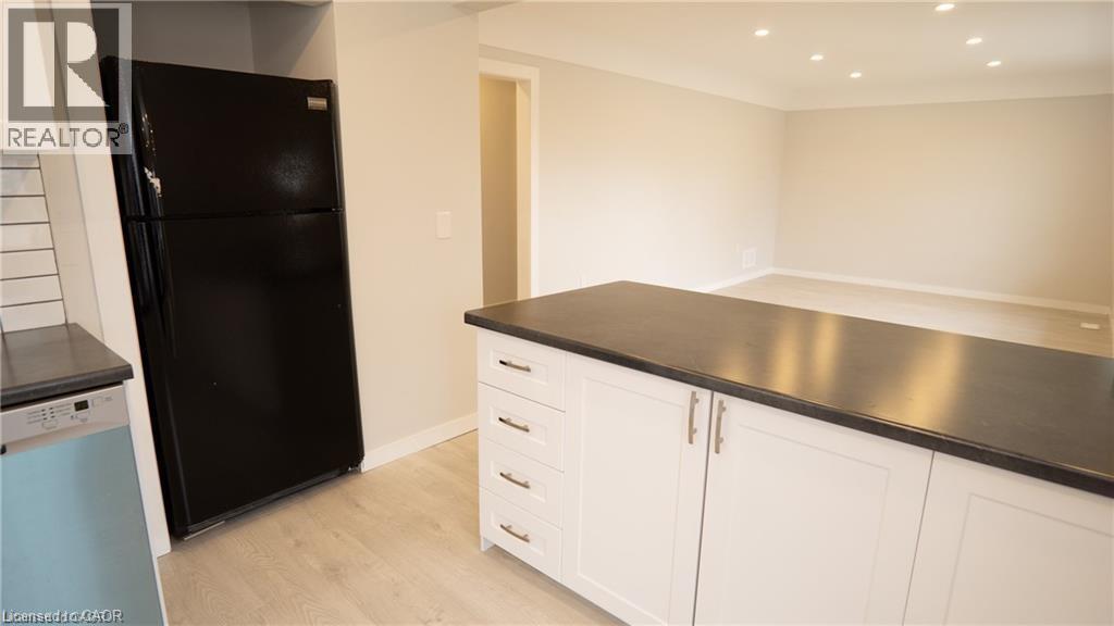 A kitchen with white cabinets and a black countertop.