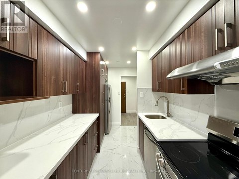 A kitchen with brown cabinets and white marble countertops.