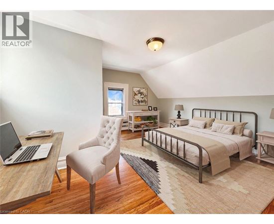 A bedroom with a bed, chair, and desk.