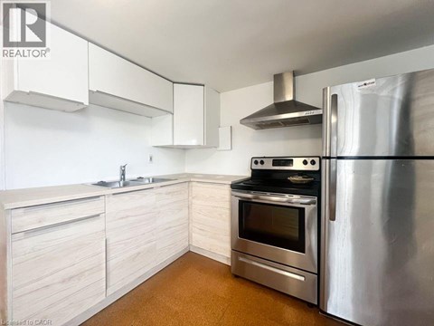 A modern kitchen with a stainless steel refrigerator and oven.