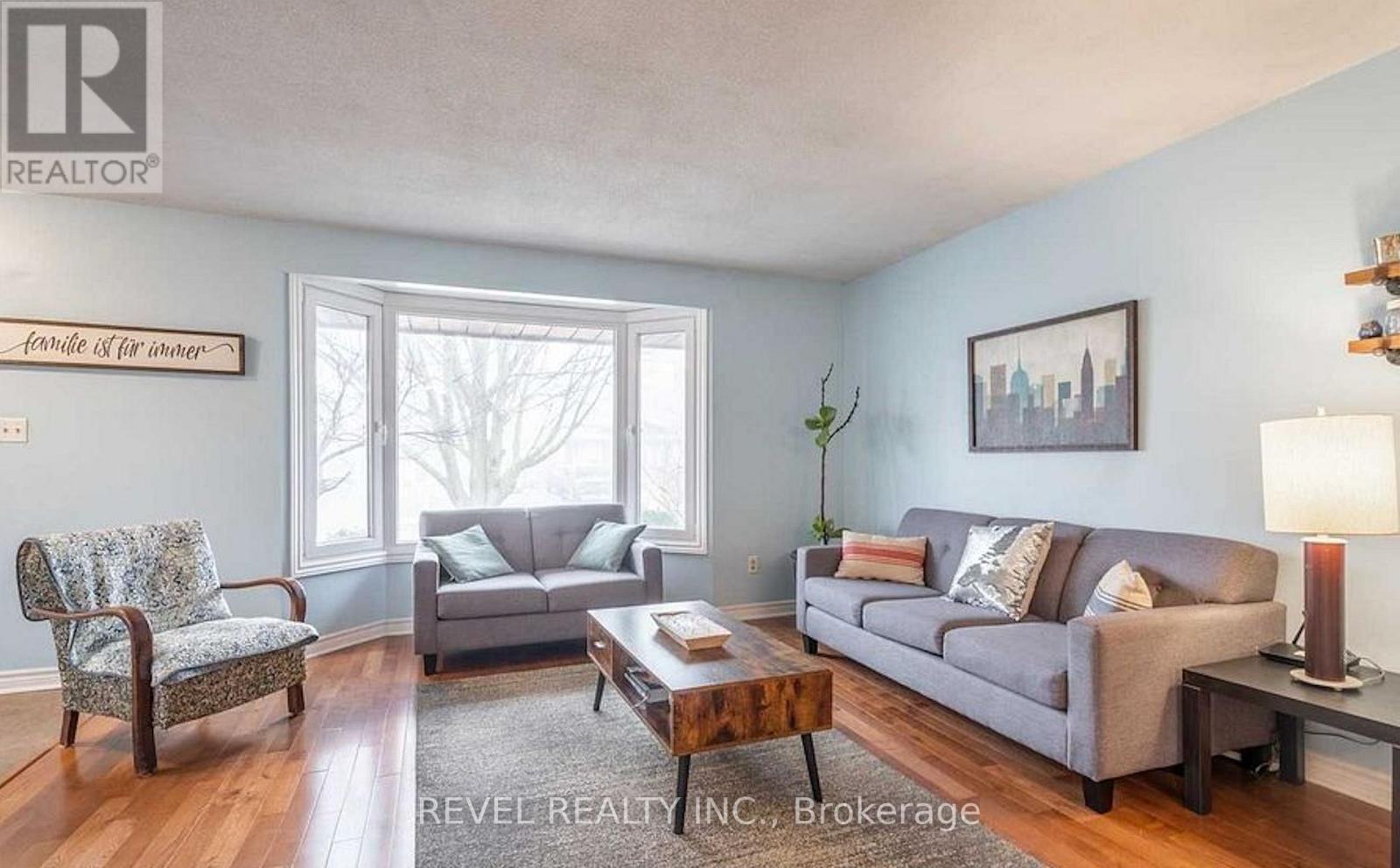 A living room with a grey couch, a wooden coffee table, and a chair with a floral pattern.