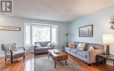 A living room with a grey couch, a wooden coffee table, and a chair with a floral pattern.