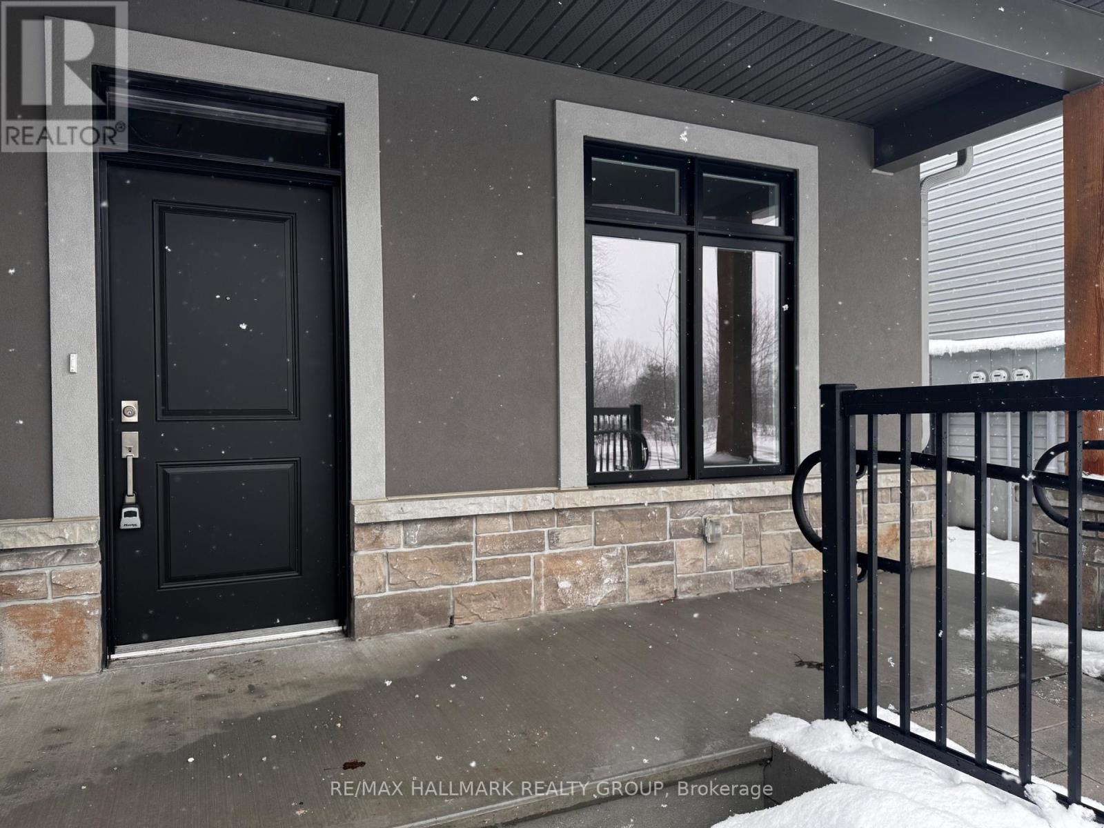 A black door and window on a house with a black gate.