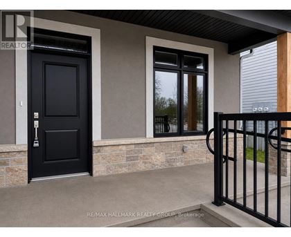 A black door and window on a house with a black gate.