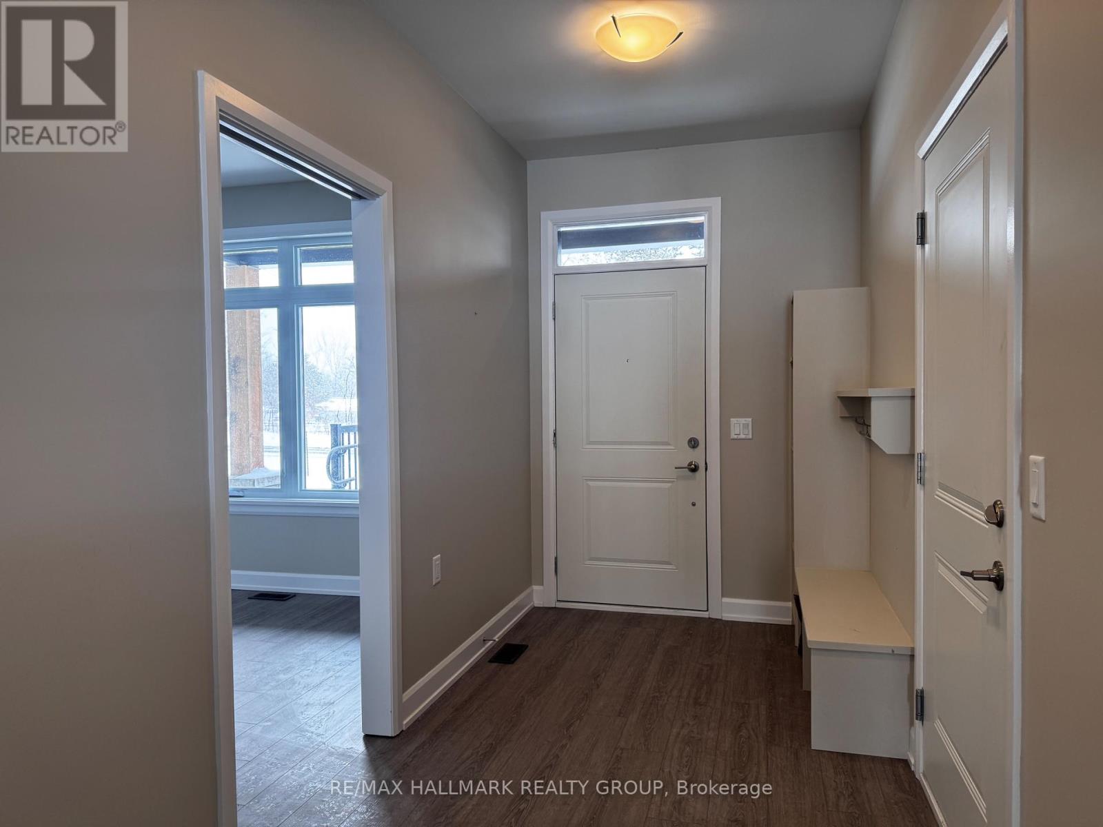 A room with a door, a window, and a bench.