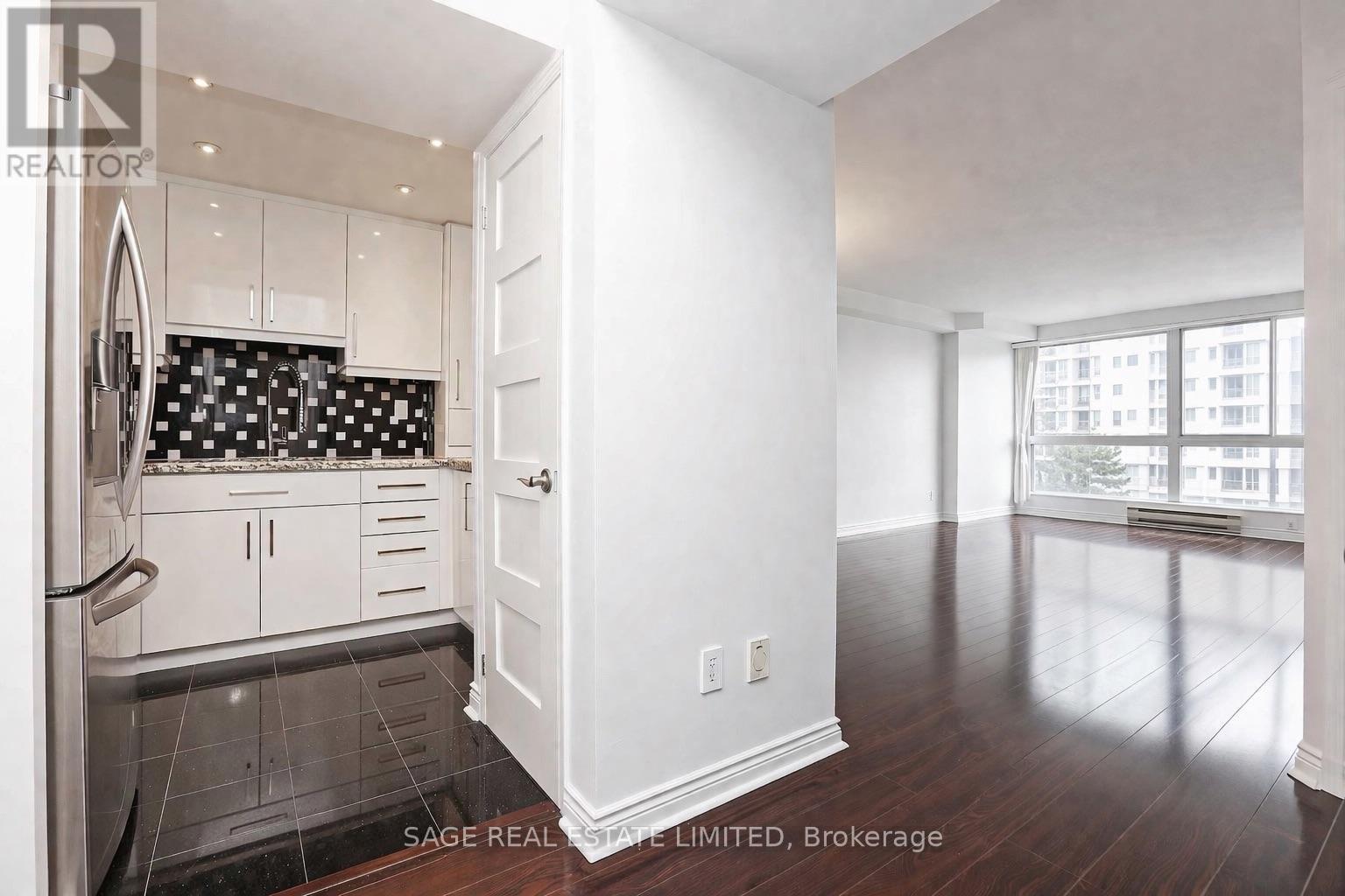 A kitchen with white cabinets and a black and white tile backsplash.