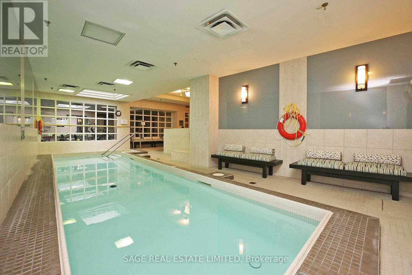 A large indoor swimming pool with a glass wall on one side.