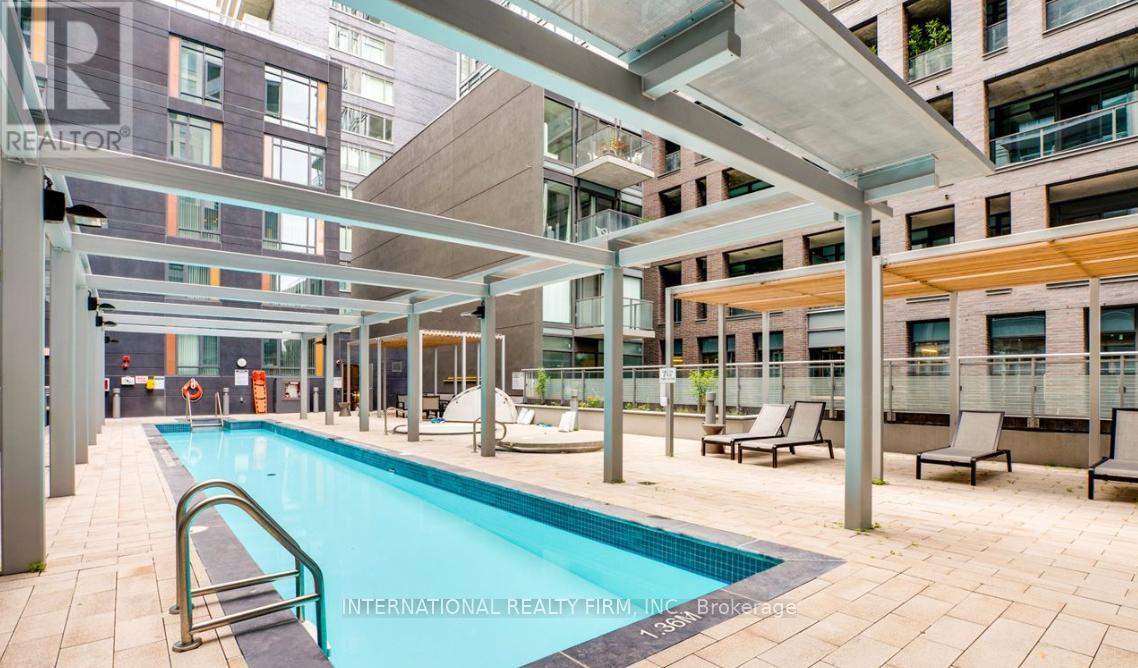 A swimming pool is surrounded by lounge chairs and umbrellas.