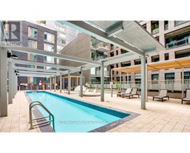 A swimming pool is surrounded by lounge chairs and umbrellas.