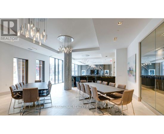 A modern dining room with a glass table and chairs.