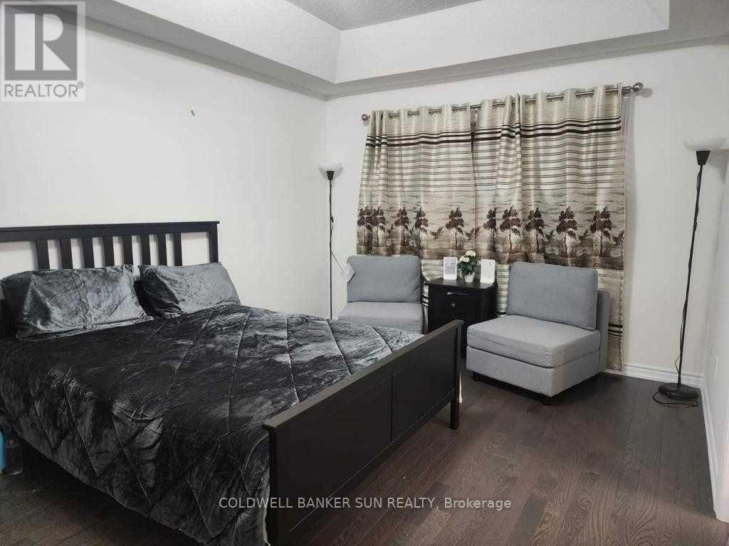 A bedroom with a bed, chair, and lamp.