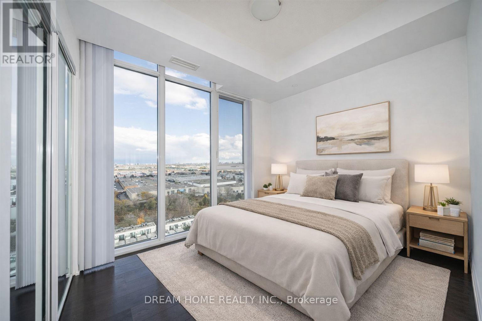 A bedroom with a large bed and a view of the city.