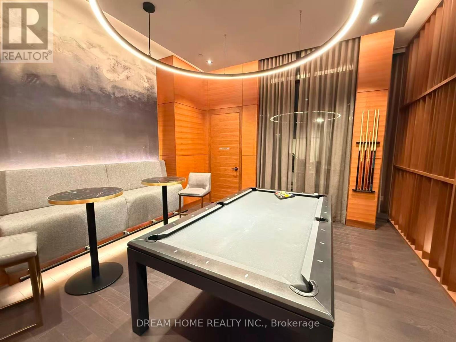 A pool table is in the middle of a room with a wood paneled wall and a glass partition.