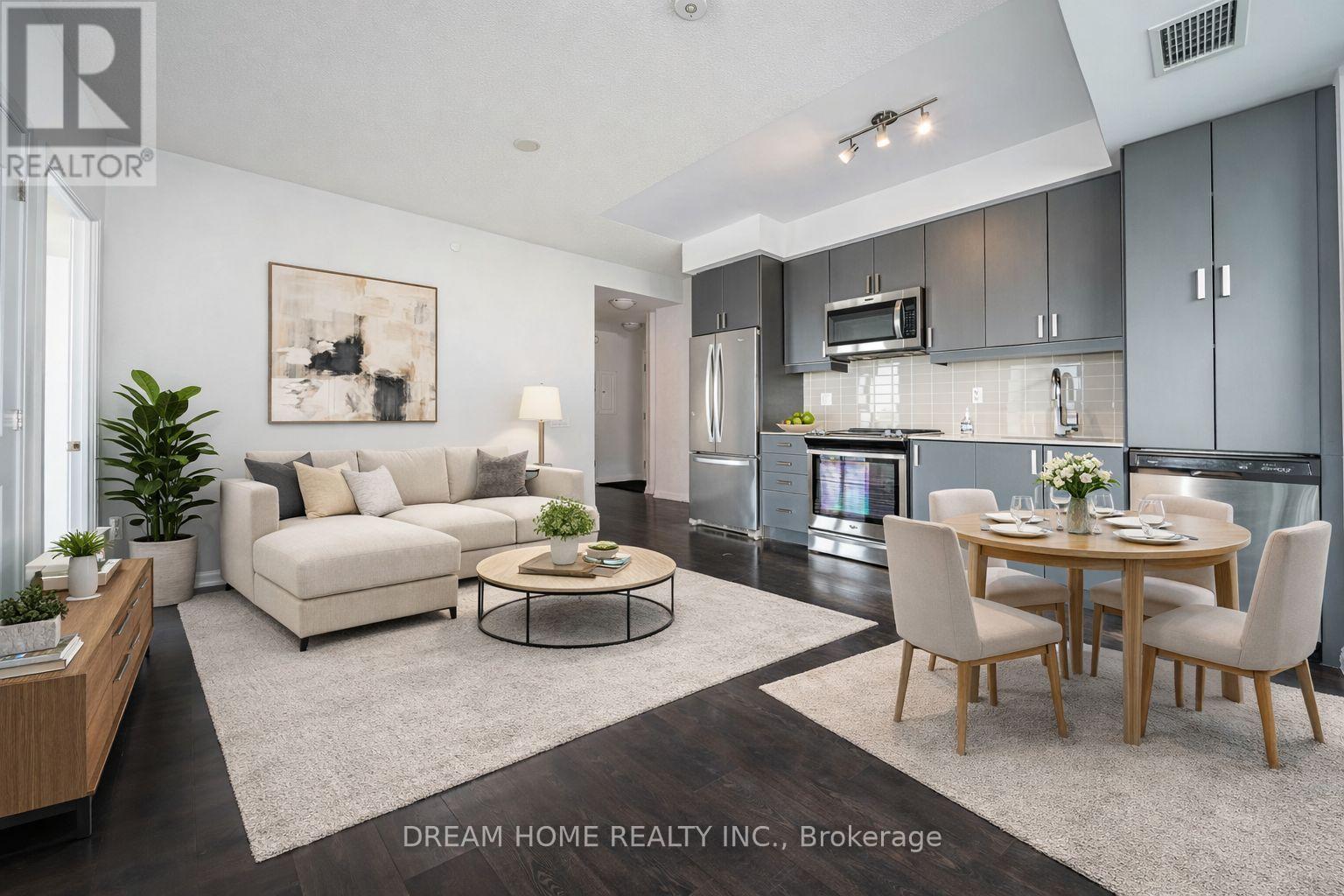 A modern kitchen and living room with a dining table set for two.