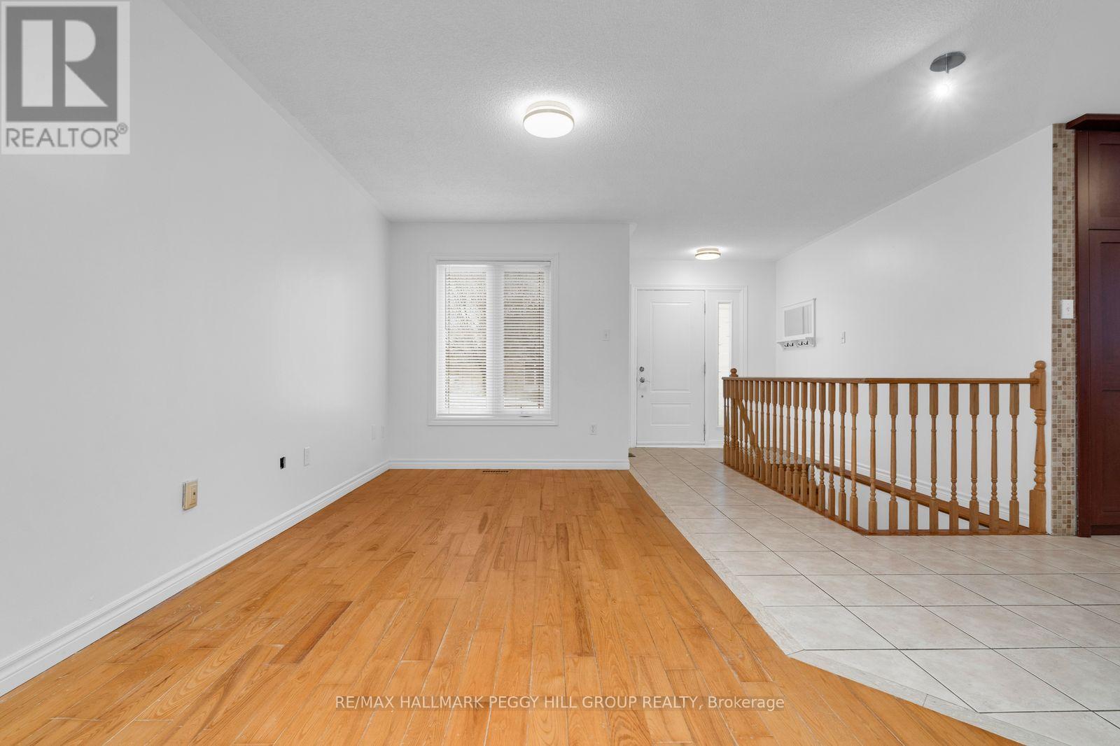 A spacious room with a wooden floor and white walls.
