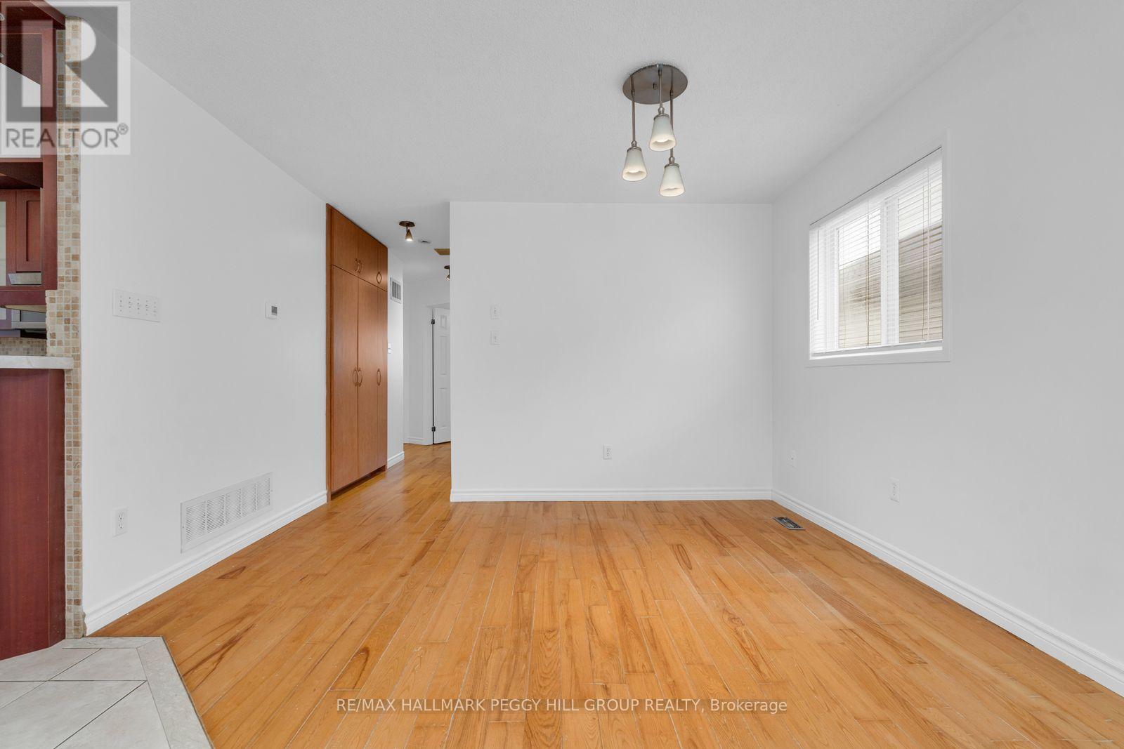 A large empty room with wooden floors and white walls.
