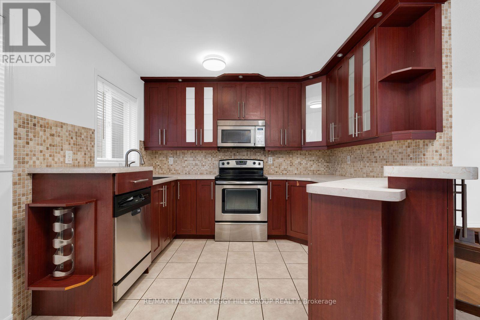 A kitchen with brown cabinets and a tiled backsplash.