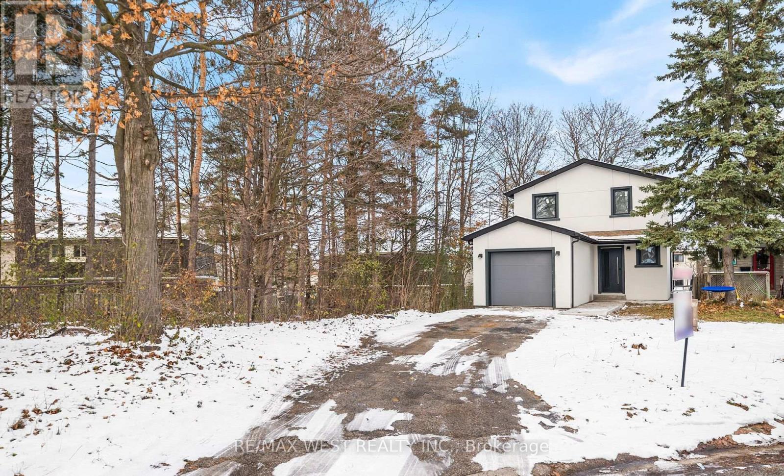 A house with a snow-covered driveway in front of it.