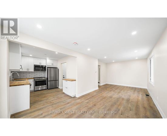 A spacious kitchen with white cabinets and a wooden countertop.