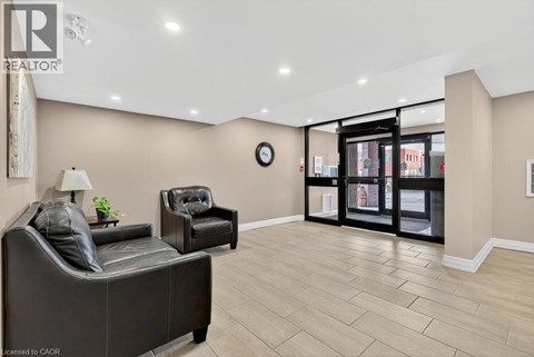A living room with a black leather sofa and a black leather chair.