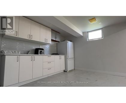 A white kitchen with a refrigerator and cabinets.
