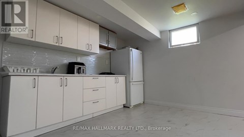 A white kitchen with a refrigerator and cabinets.