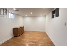 A room with a wooden floor and a brown dresser.