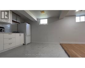 A kitchen with white cabinets and a refrigerator is shown.