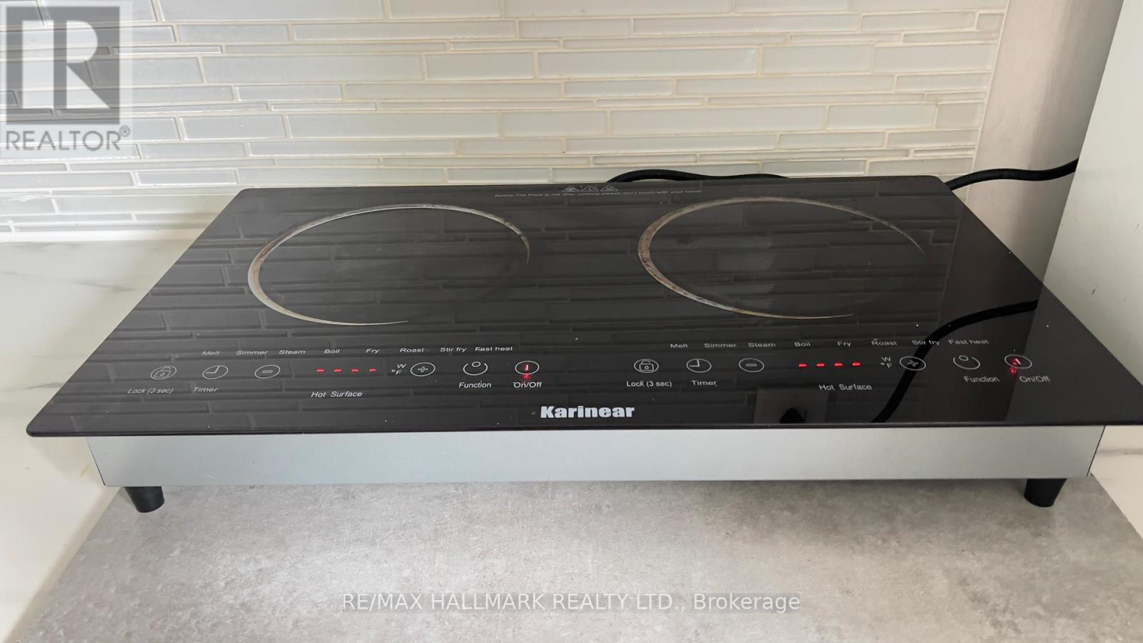 A KitchenAid brand stove top is on a grey counter.