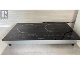 A KitchenAid brand stove top is on a grey counter.
