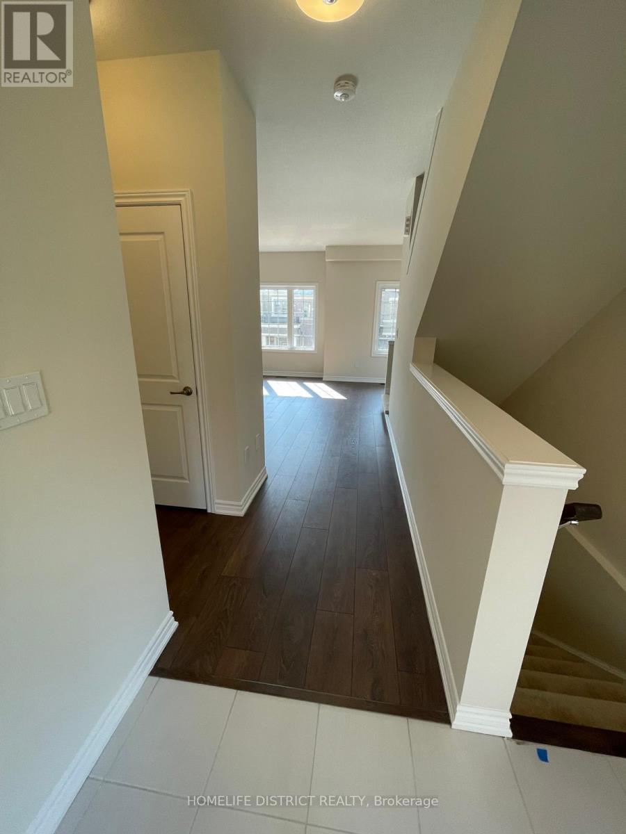 A hallway with a staircase and a door leading to another room.
